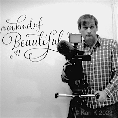 Mustavalkoisessa valokuvassa henkilö videokuvaamassa yritysvideota.